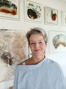 Künstlerin vor abstrakten Gemälden. Moderne Kunstausstellung mit Frau im Atelier.