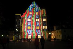 Fantasievolles Gebäude in Deutschland. Buntes Haus mit Lichtern bei Nacht. Architektur und Design.