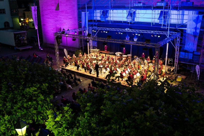 Konzertabend: Orchester spielt auf der Bühne vor Publikum. Musikveranstaltung mit Beleuchtung.