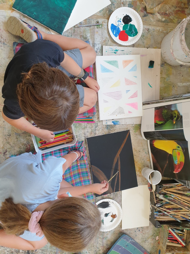 Zwei Kinder malen. Mädchen mit Pinsel, Junge mit Stiften. Kunstprojekt, kreative Kinder, Malerei.